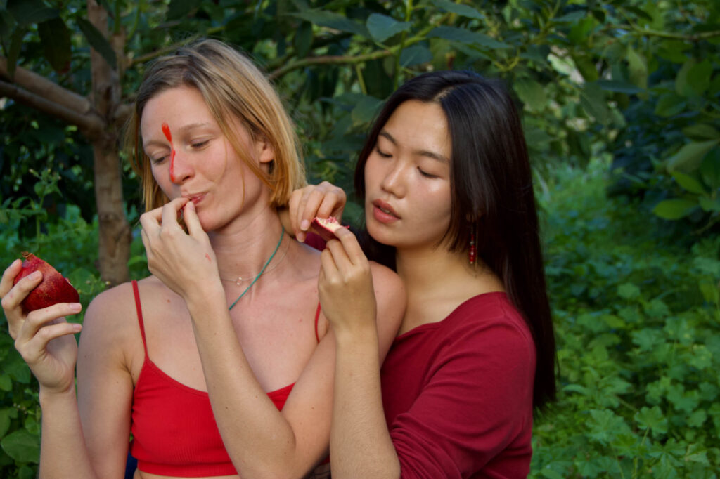 Two women in nature with apple.